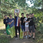 Grupa uczniów z workami na śmieci w lesie