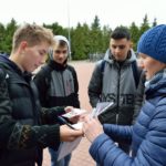 3 uczniów z Anną Rutkowską na placu szkolnym