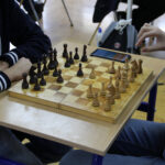 Uczeń przymierzający się do wykonania ruchu figurą szachową