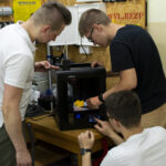 Uczniowie z opiekunem przy drukarce 3D