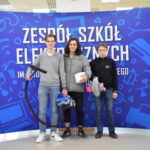Dzień bez plecaka w ZSE; trzech uczniów na tle baneru ZSE