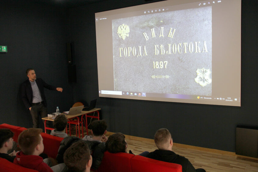 O XIX-wiecznej historii Białegostoku - W. Wróbel, w tle slajd z prezentacji, uczestnicy spotkania
