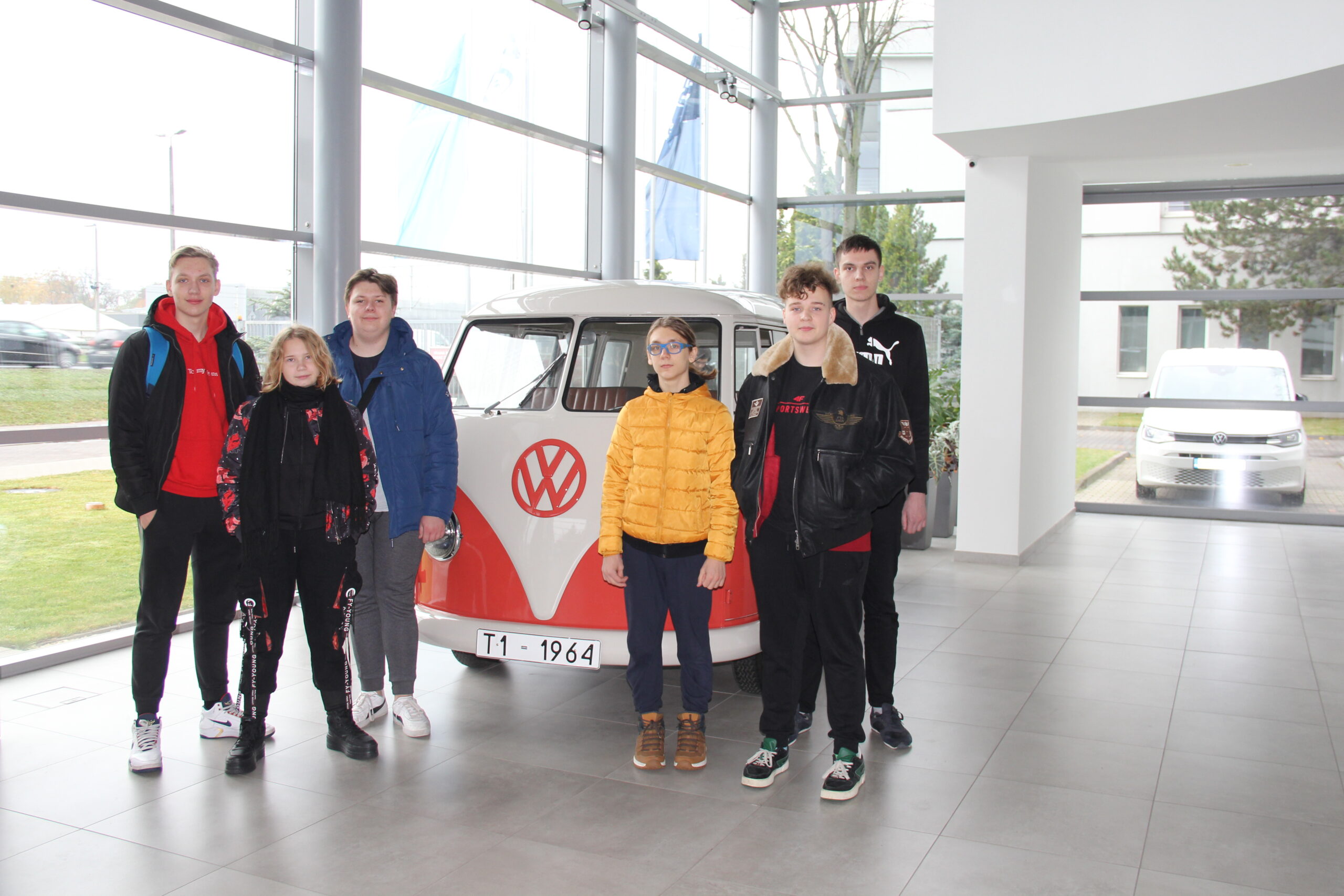 6 uczniów na tle zabytkowego samochodu Volkswagena